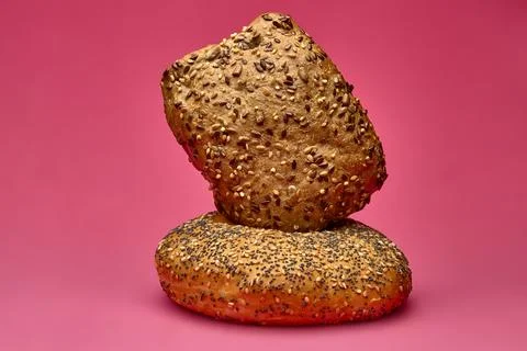 Triangular bread roll stacked on round bun with pink background Stock Photos