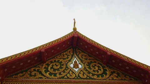 Triangular Buddhist temple top, golden decorations, golden bush relief, sky 스톡 동영상 76813379