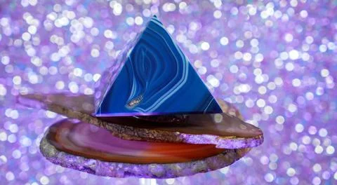 A triangular cake decorated with toppings on top of glittery surface Foto stock