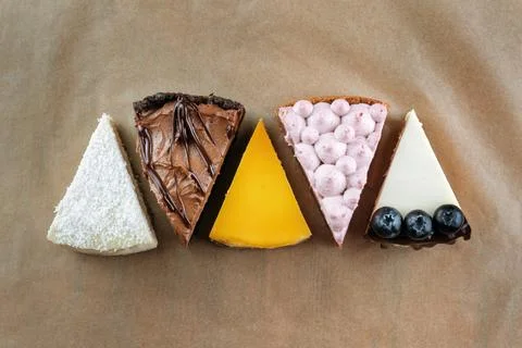 Triangular Cake Pieces Assorted Flavors, Coconut, Chocolate, Orange, Blueberry Stock Photos