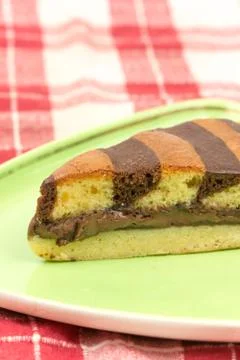 Triangular chocolate cake on green triangular plate 스톡 사진