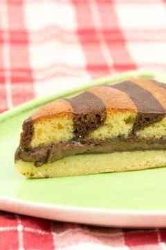 Triangular chocolate cake on green triangular plate Foto stock