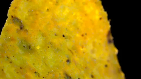 Triangular Corn Nacho Chip Rotating on Black Background, Macro View Stock Footage 345610652