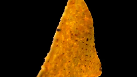 Triangular Corn Nacho Chip With Seasoning on Black Background, Extreme Macro Stock Footage 345610599
