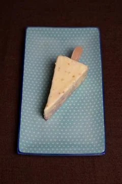 Triangular dessert on a stick in white chocolate Stock Photos