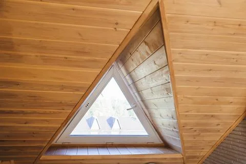 A triangular dormer window on the attic floor, viewed from inside the house Foto stock