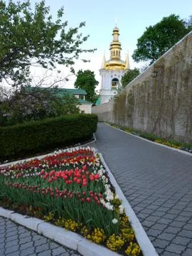 Triangular flowerbed with multi-colored tulips against a beautiful church chu Stock Photos