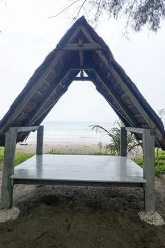 A triangular gazebo roofed with palm leaves, photo from the front Stock Photos