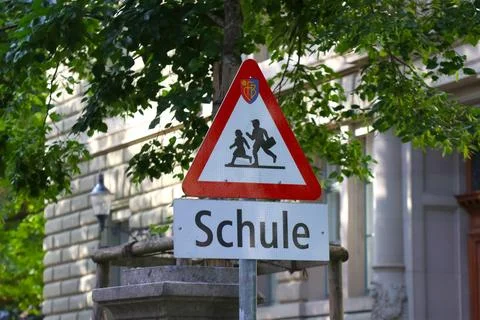 A triangular german school zone warning sign, featuring silhouettes of childr Stock Photos
