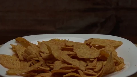 The triangular golden chips fall on the plate Stock Footage 78529701