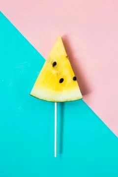 Triangular ice cream slices on a stick of ripe yellow watermelon Stock Photos
