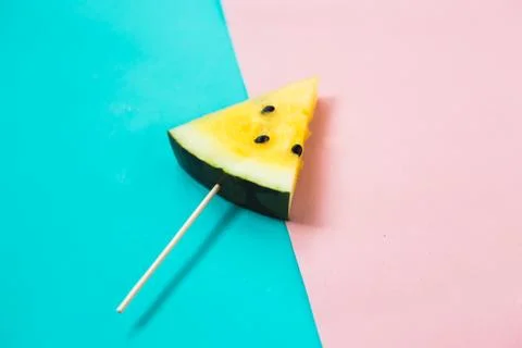 Triangular ice cream slices on a stick of ripe yellow watermelon Stockfoto's
