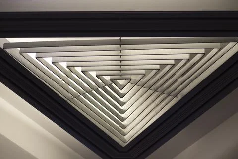 Triangular lamp in interior. Design of lighting device. Lamp on ceiling. 스톡 사진