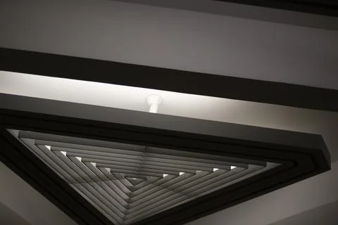Triangular lamp in interior. Design of lighting device. Lamp on ceiling. 스톡 사진