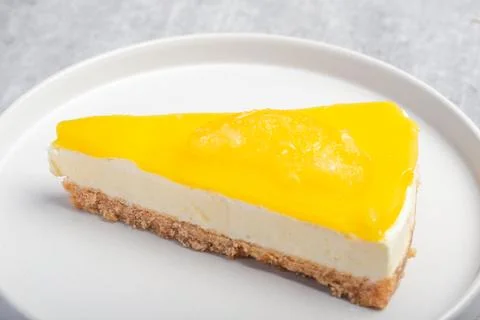 Triangular lemon cheesecake on a white plate Stock Photos