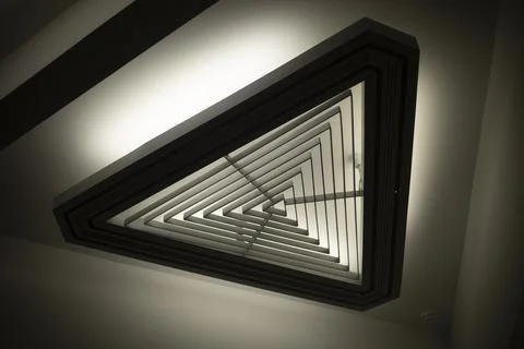 Triangular light source. Lamp in interior. Designer light. Architecture detai Stock Photos