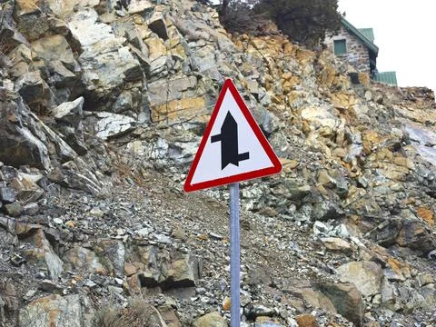 Triangular Merge Warning Sign On Rocky Road Stock Photos
