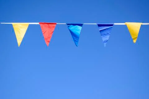 Triangular multi-colored flags hang on a rope Stock Photos