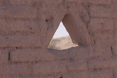 Triangular opening in a textured adobe wall frames Foto stock