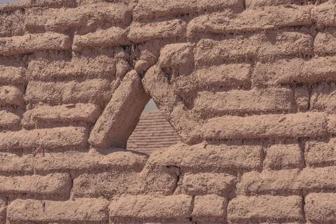 Triangular opening in a textured adobe wall frames Stock Photos