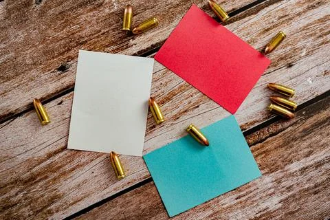 Triangular ordered white blue and red empty notes with scattered 9 mm bullet Stock Photos