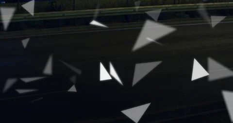 Triangular particles drifting and rotating across dark roadway, triggered by red Stock Footage 322221088