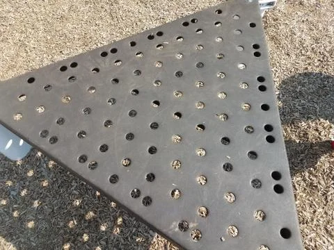 Triangular piece of metal with circular holes in it Stock Photos