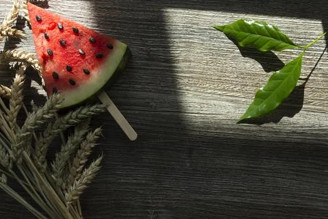 A triangular piece of sweet watermelon on an ice cream shelf, a cold drink wi Stock Photos