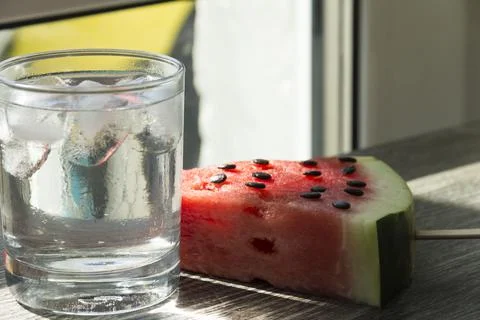 A triangular piece of sweet watermelon on an ice cream shelf and a cold drink Stock Photos