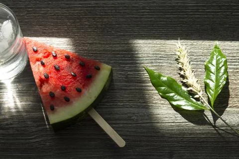 A triangular piece of sweet watermelon on an ice cream shelf, a cold drink wi Stock Photos