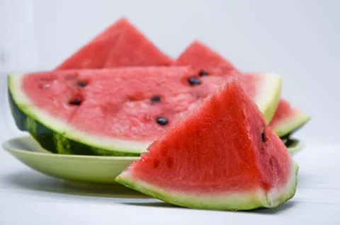 Triangular piece of watermelon and a plate of watermelon slices Stock Photos