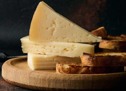 Triangular pieces of cheese on a wooden board Stock Photos