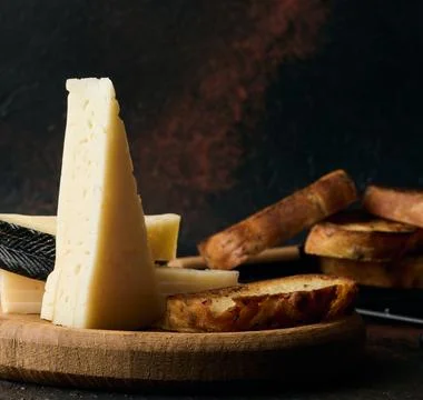 Triangular pieces of cheese on a wooden board Stock Photos