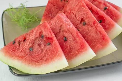 Triangular pieces of red ripe watermelon on a plate. Close up. Background Stock Photos