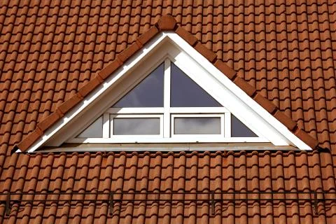 Triangular plastic window on the roof with tiles Stock Photos
