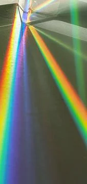 Triangular prism in sunlight with rainbow lines Stockfoto's
