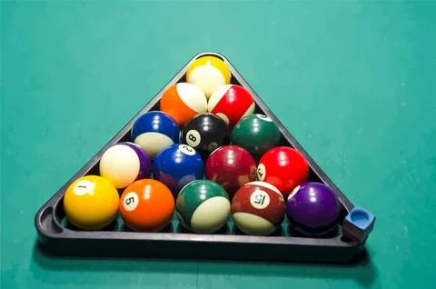 Triangular rack of billiard balls on green table Stock Photos