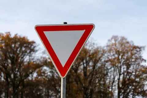 Triangular Red and White Traffic Sign with Autumn Trees Stock Photos