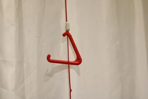 Triangular red emergency pull cord against neutral background with copy space Stock Photos