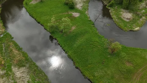 Triangular River Meander – Wide Forward Tilt‑Up Aerial Reveal Movement Stock Footage 335284200