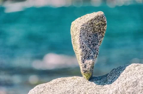 Triangular rock balanced on the tip in Vancouver rock stacking garden Stock Photos