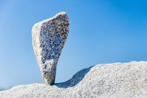 Triangular rock balanced on the tip in Vancouver rock stacking garden Stock Photos