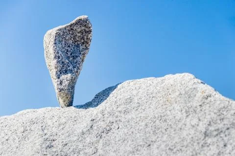 Triangular rock balanced on the tip in Vancouver rock stacking garden Stock Photos