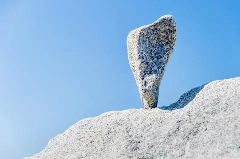 Triangular rock balanced on the tip in Vancouver rock stacking garden Stock Photos