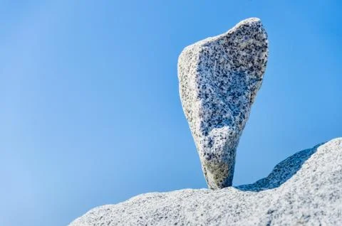 Triangular rock balanced on the tip in Vancouver rock stacking garden Stock Photos