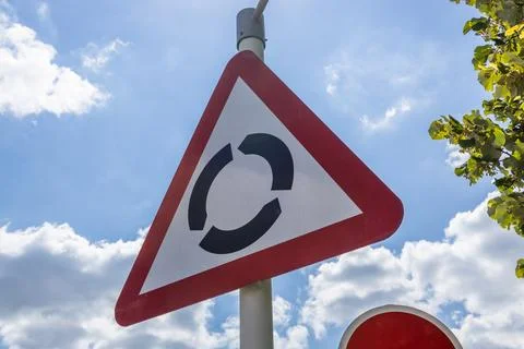 Triangular roundabout traffic sign on street Stock Photos