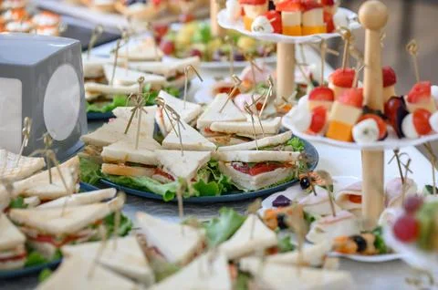 Triangular sandwiches with tomatoes and herbs on plates during a buffet Foto stock