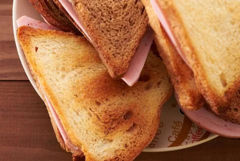 Triangular sandwiches on wooden table Stock Photos
