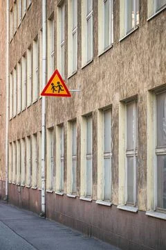 Triangular school crossing sign on old building wall. Stock Photos