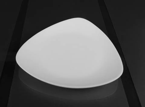 Triangular shallow porcelain bowl for serving food Foto stock